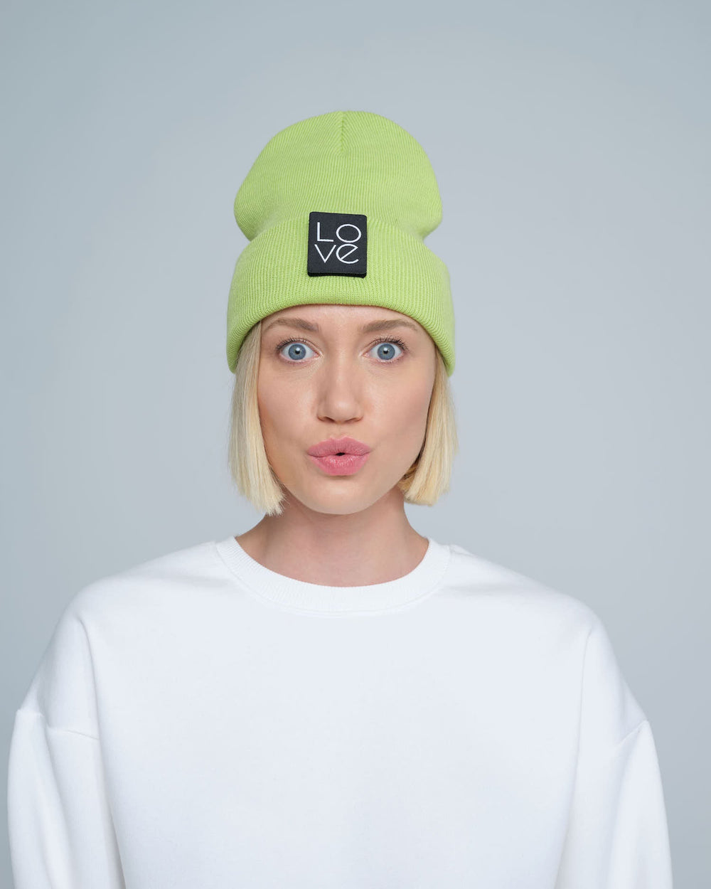 model wearing light green patch ready beanie with LOVE text patch on the front