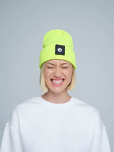 women wearing neon yellow beanie with a 'e' letter patch on it