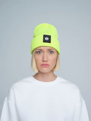 women wearing neon yellow beanie with a 'e' letter patch on it