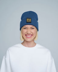 female model wearing steel blue beanie with a crown patch on it