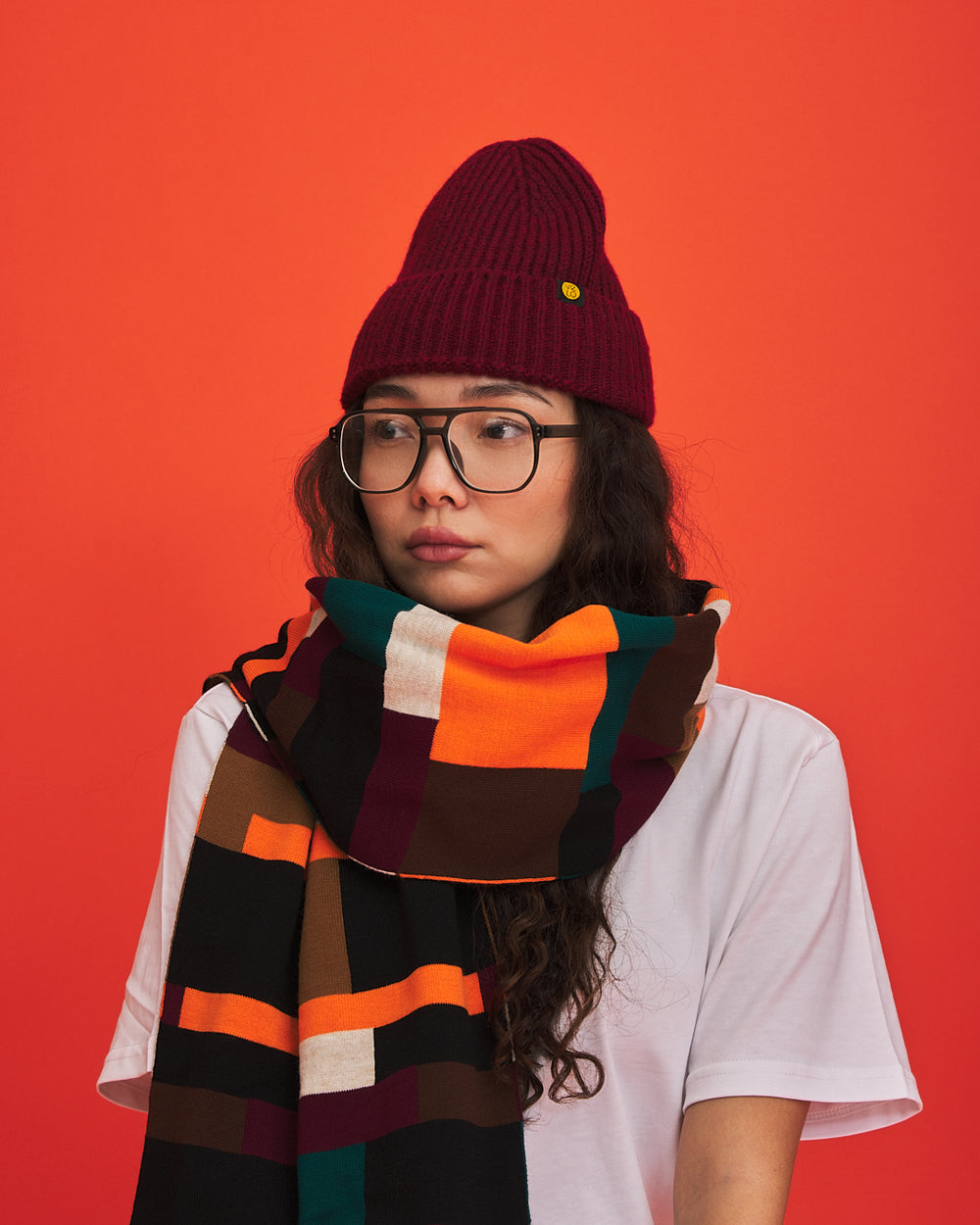 Brick Grid scarf styled against an orange studio background