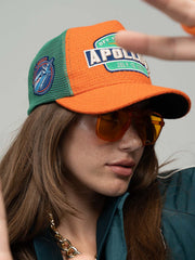 Person wearing Apollo Orange Trucker Hat and sunglasses.