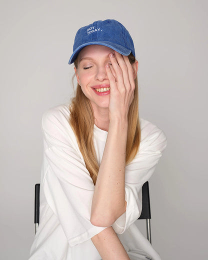 woman smiling and wearing Blue Washed Cap with Not Today embroidered in white