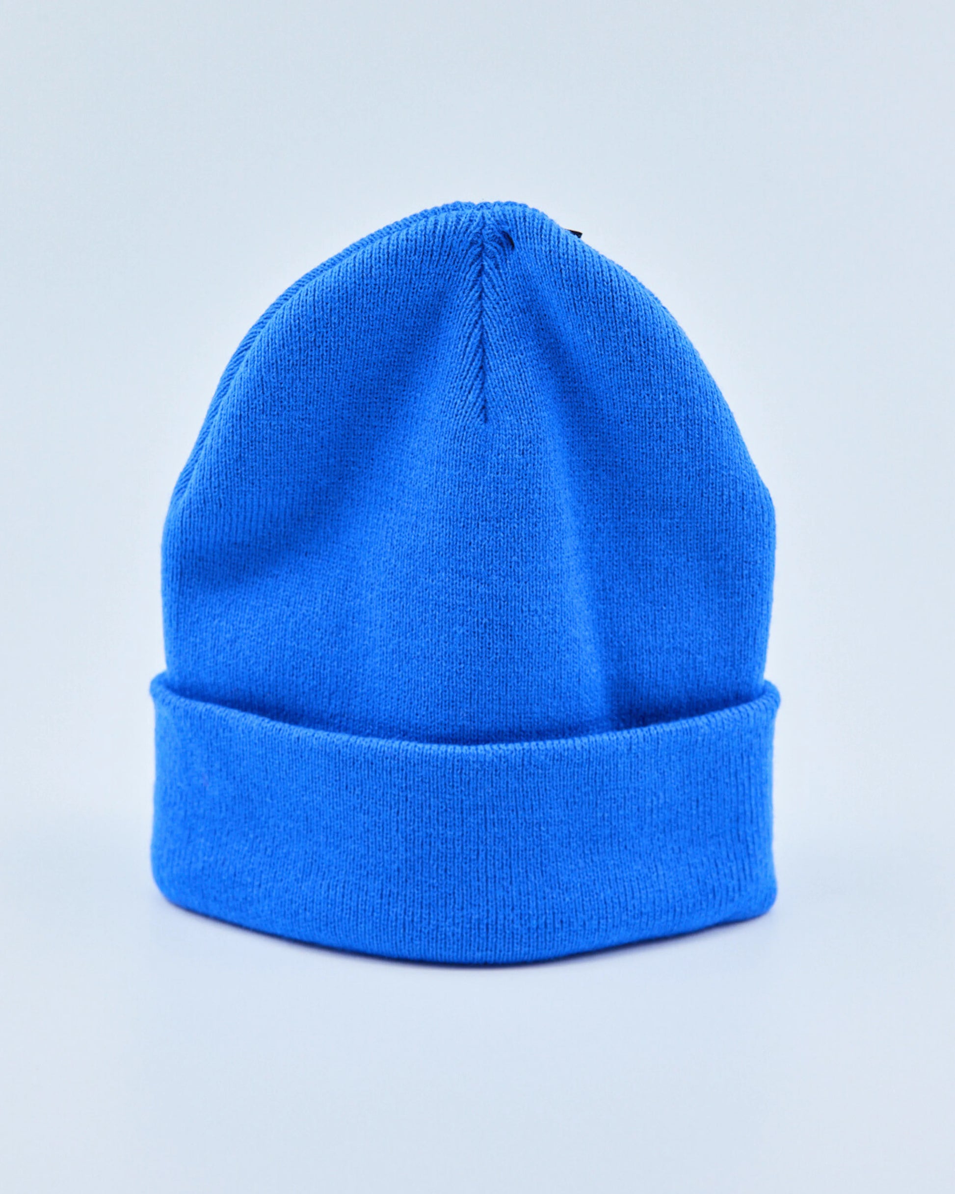 Bright blue beanie on a light gray background
