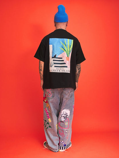 Person wearing a black t-shirt with a colorful graphic on the back against an orange background