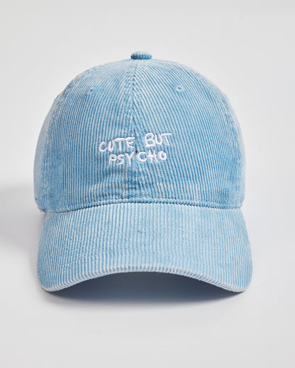 Light blue corduroy cap with 'Cute But Psycho' text on a light gray background