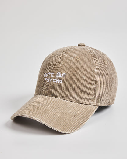Beige cap with 'Cute But Psycho' text on a light gray background