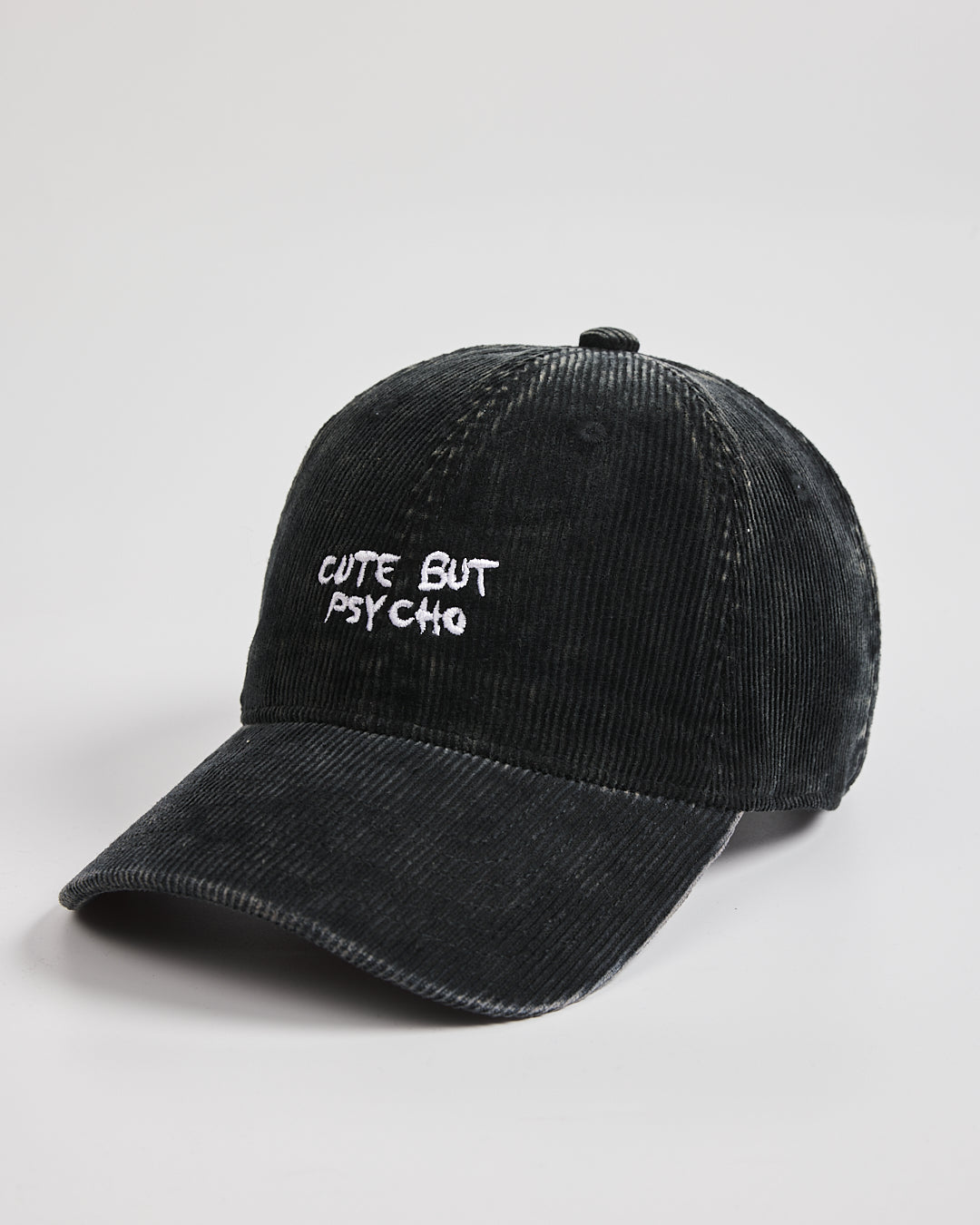 Black cap with 'Cute But Psycho' text on a light gray background