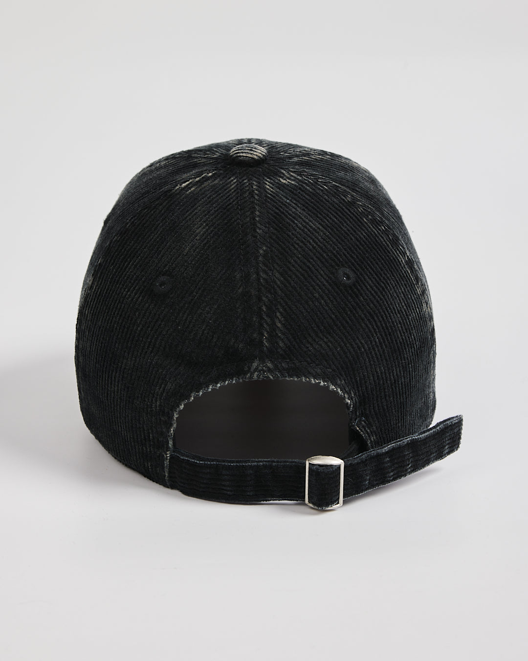 Black corduroy cap on a light gray background
