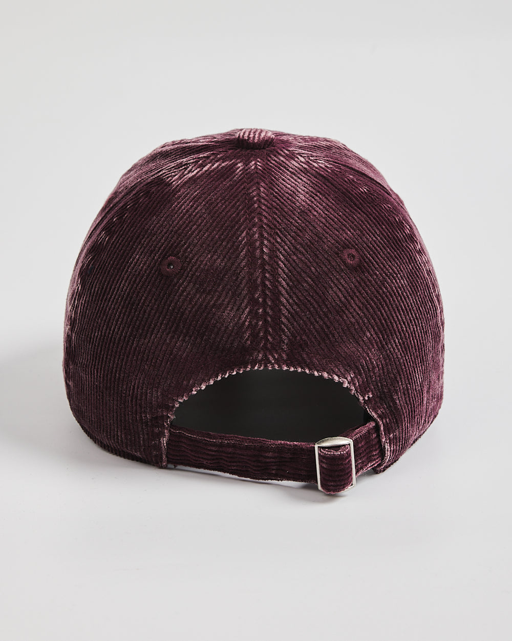 Burgundy corduroy cap on a light gray background
