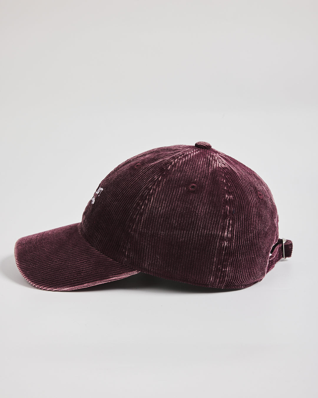 Burgundy corduroy cap on a light gray background