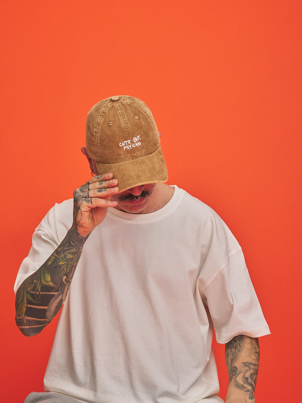 Person wearing a camel cap with text on an orange background