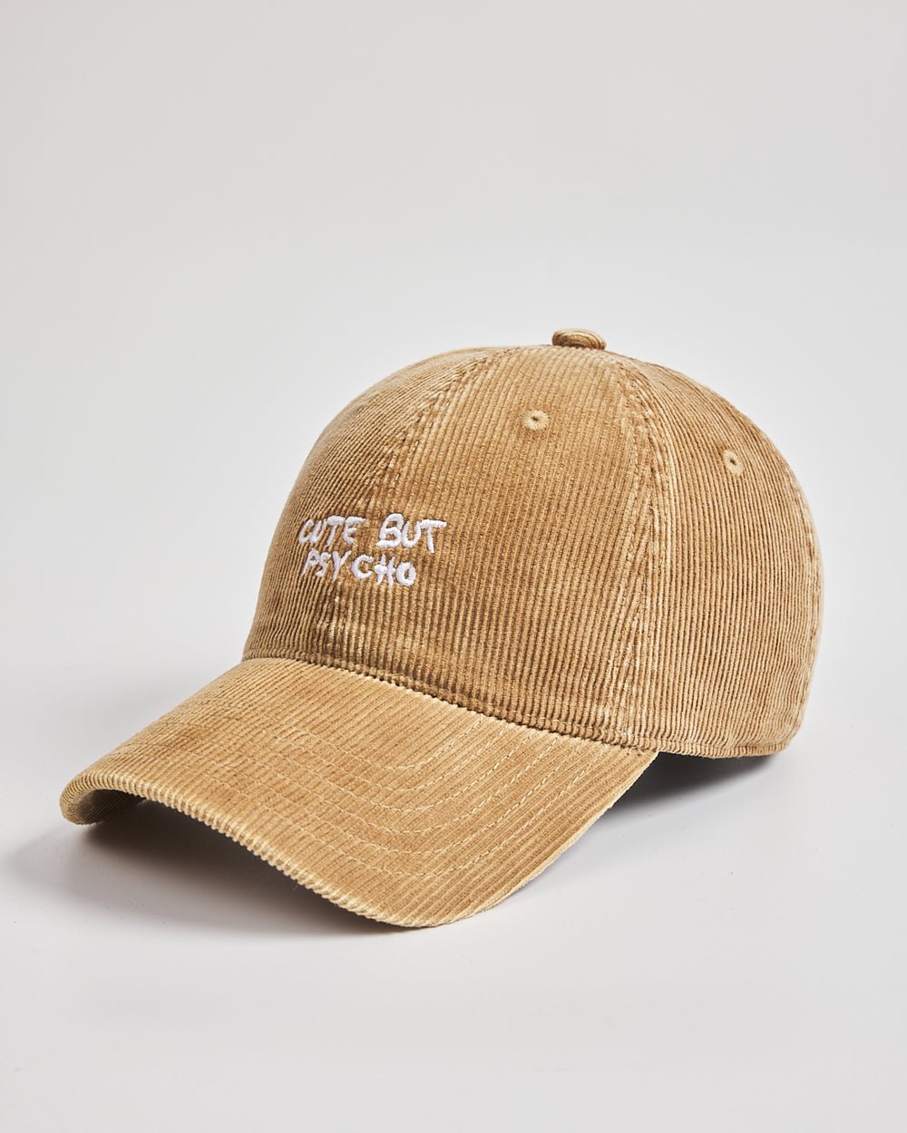 Camel cap with 'Cute But Psycho' text on a light gray background