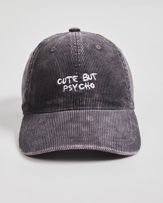 Gray corduroy cap with 'Cute But Psycho' text on a light gray background