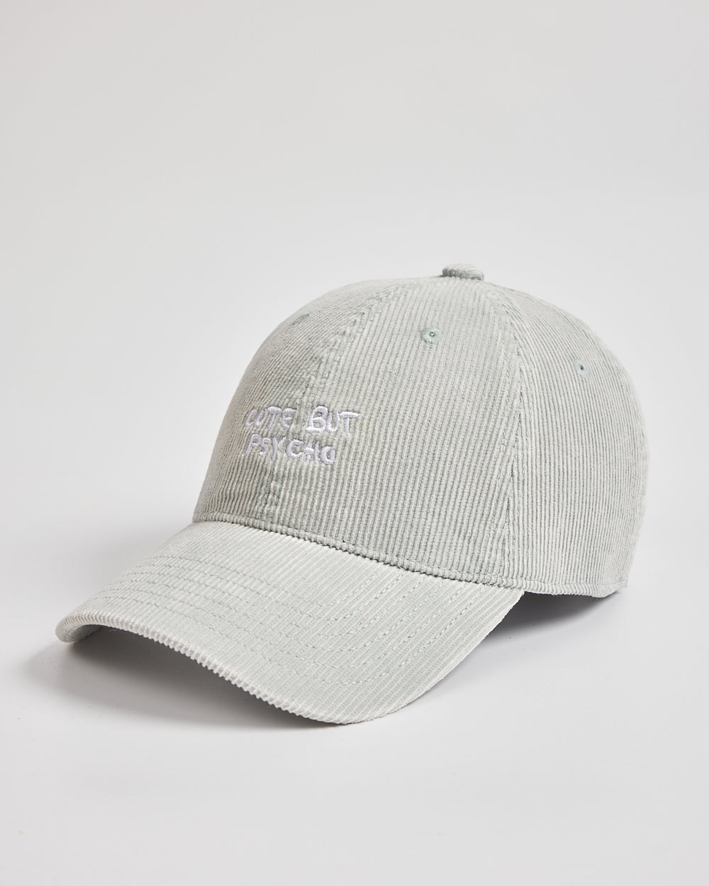 Side look of light grey Cute But Psycho cap with branding on a light grey background