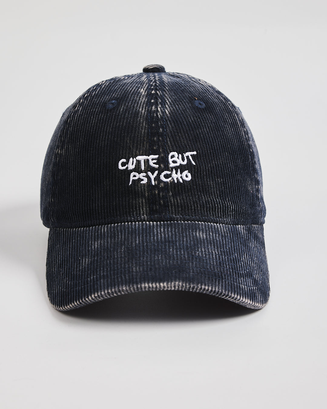 Navy Corduroy Cap with 'Cute But Psycho' text on a light gray background