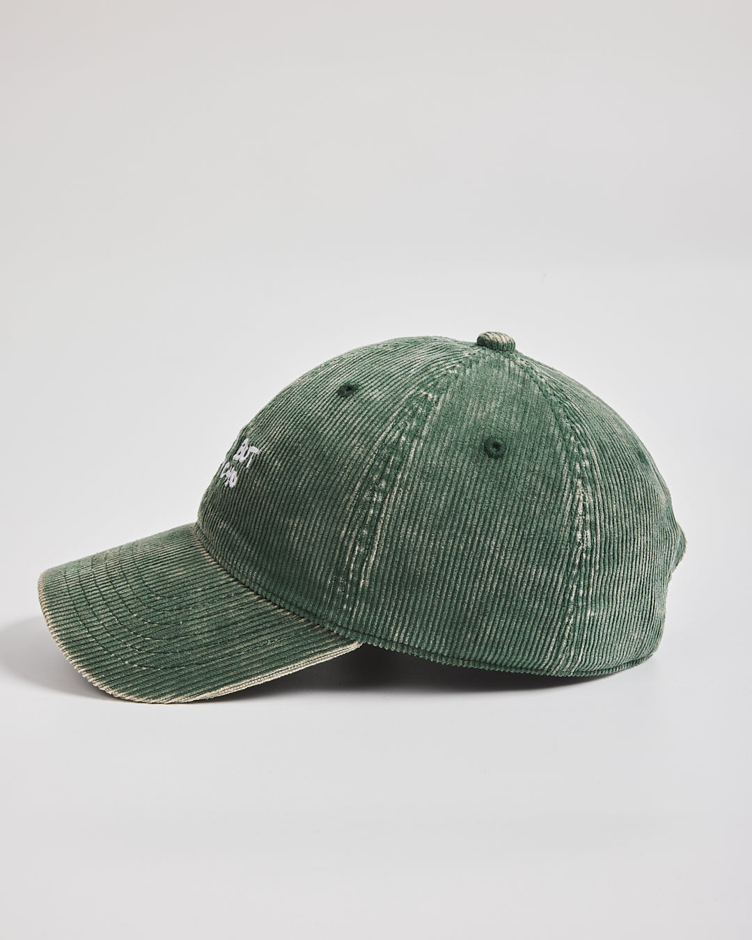 Side look of green corduroy cap on a light gray background
