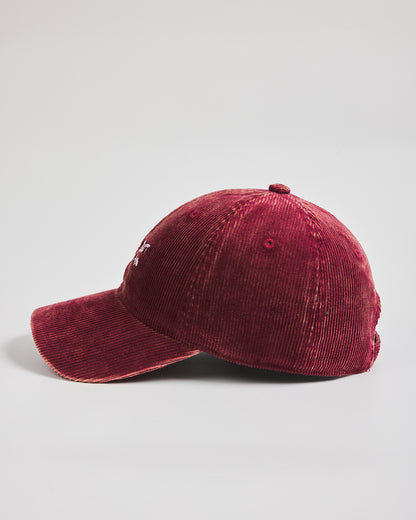 Red corduroy cap on a light gray background