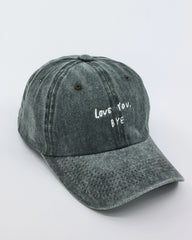 side view of Dark Green Washed Cap with 'Love You, Bye' embroidered in white.
