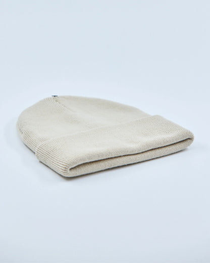 Ecru white beanie hat on a light gray background