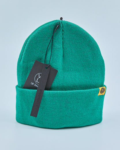 Green beanie with a tag on a light blue background