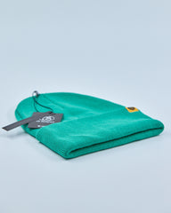 Green beanie with a tag on a light blue background