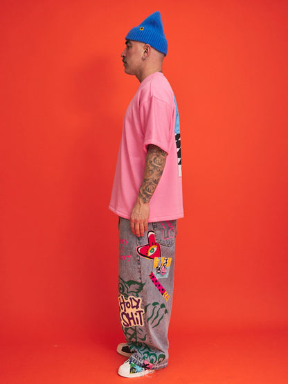 Person wearing a pink shirt, blue beanie, and colorful pants with text on an orange background