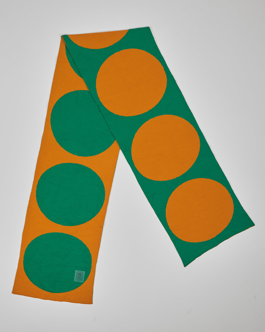 Green & Amber Dots unisex acrylic scarf flat lay in emerald green and warm amber