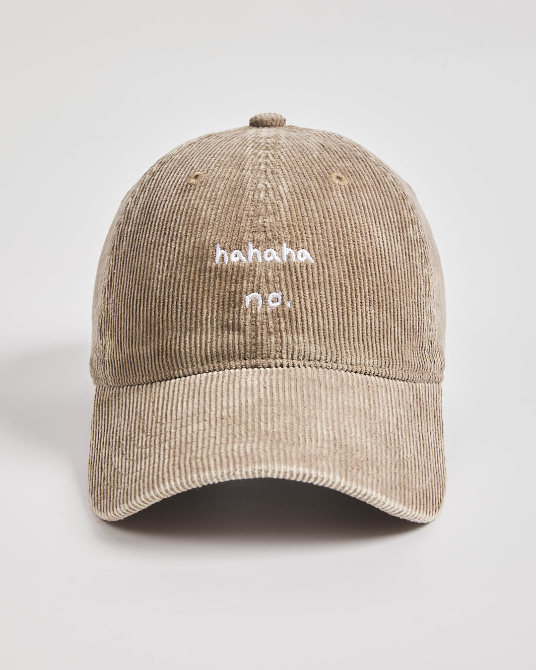Beige corduroy cap with 'hahaha no.' text on a light gray background