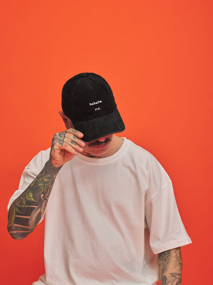 Person wearing a black cap with text on an orange background