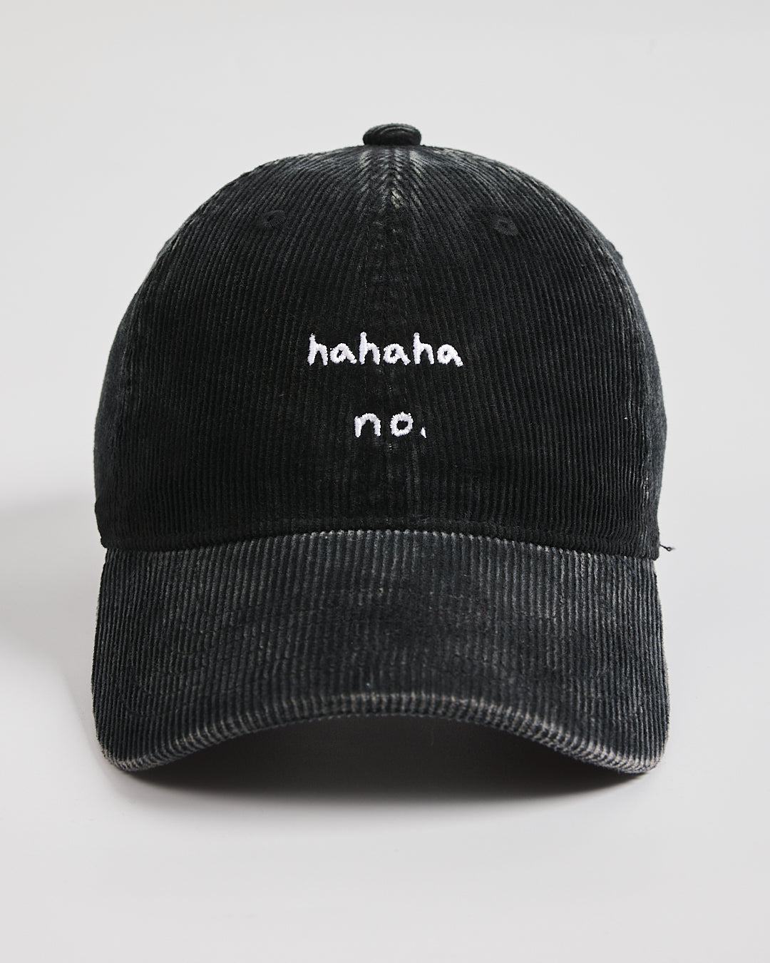 Black corduroy cap with 'hahaha no.' text on a white background