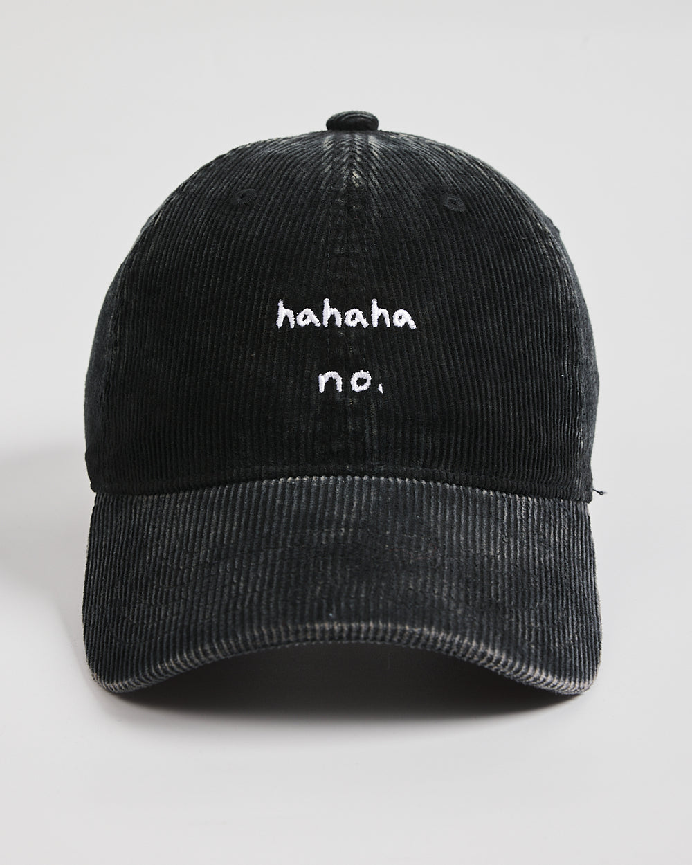 Black corduroy cap with 'hahaha no.' text on a white background