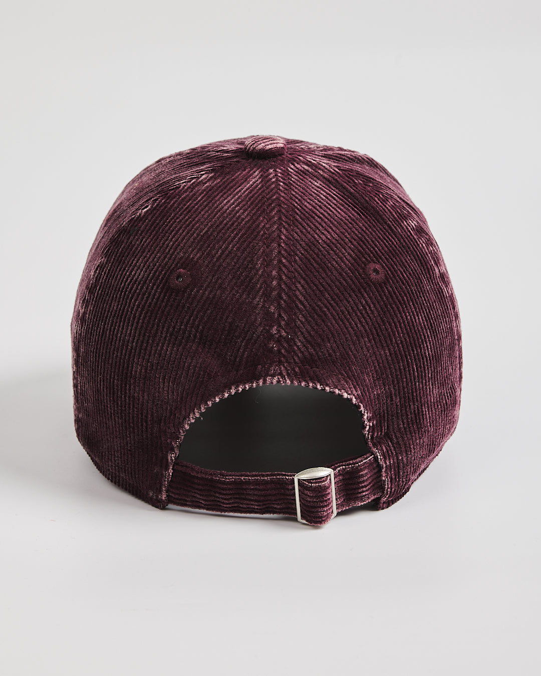 Burgundy corduroy cap on a light gray background