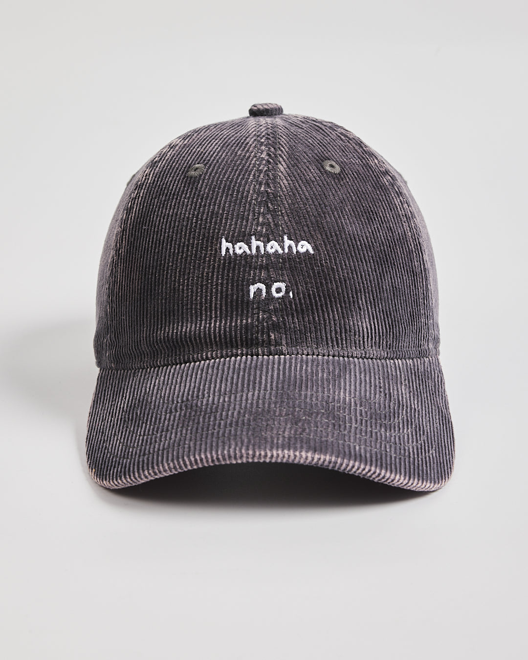 Charcoal grey corduroy cap with 'hahaha no.' text on a light gray background