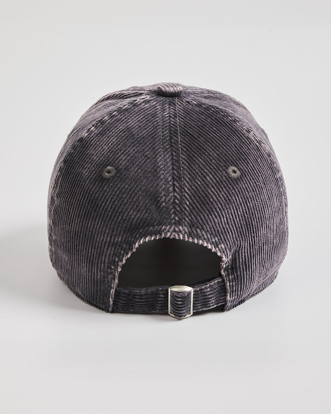 Charcoal grey corduroy cap on a light gray background