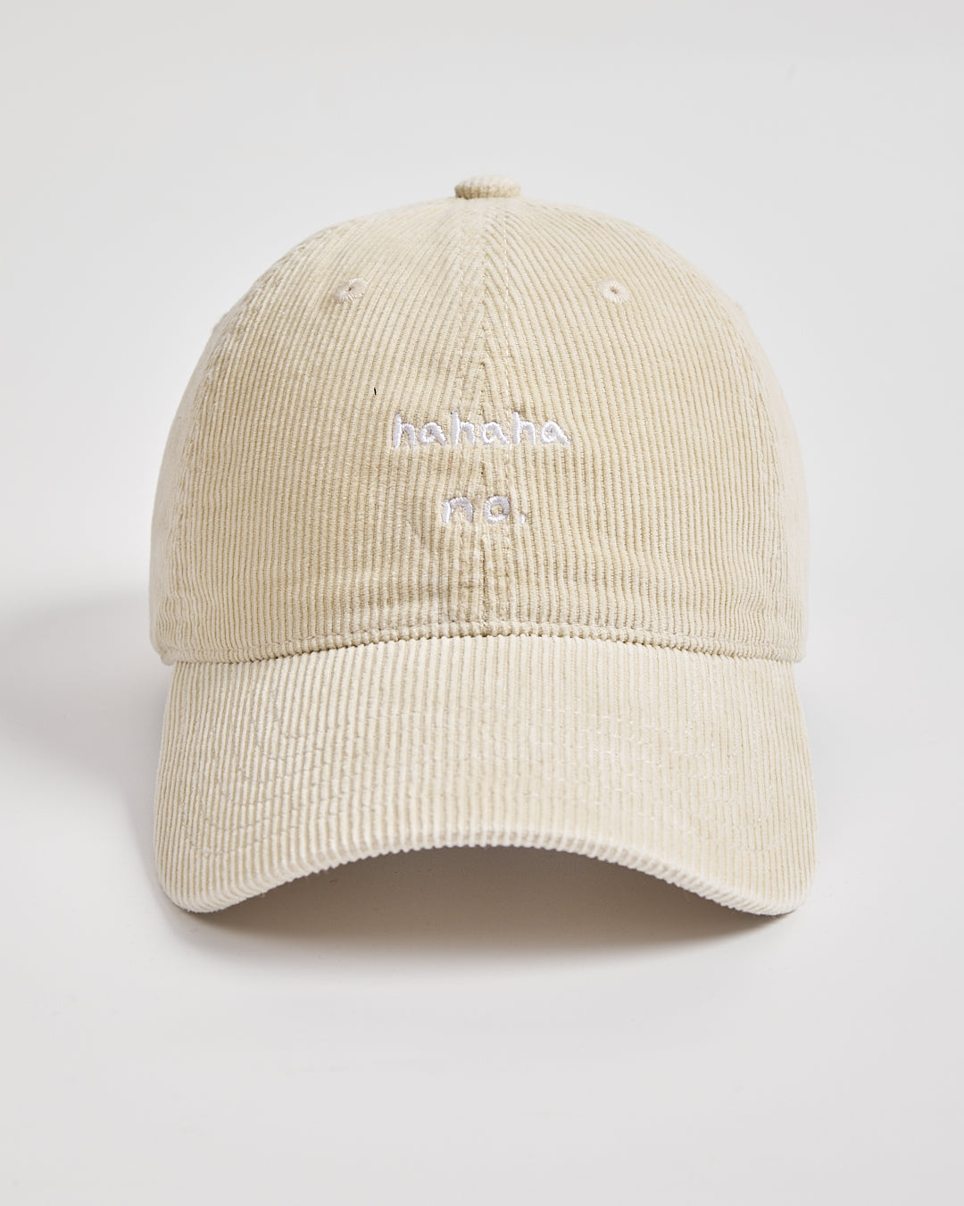Beige cream corduroy cap with white text on a light gray background