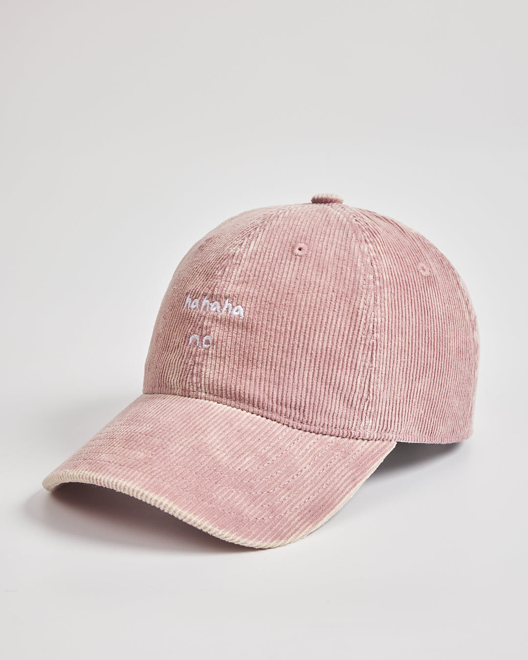 Pink corduroy cap with text on a light gray background