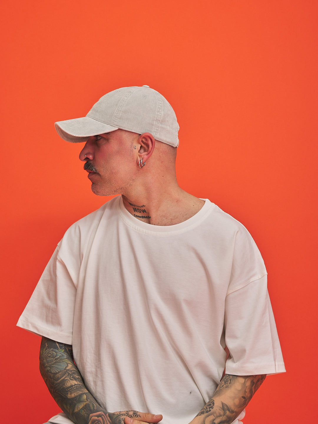 Person wearing Hahaha No Light Grey Corduroy Cap and t-shirt against an orange background