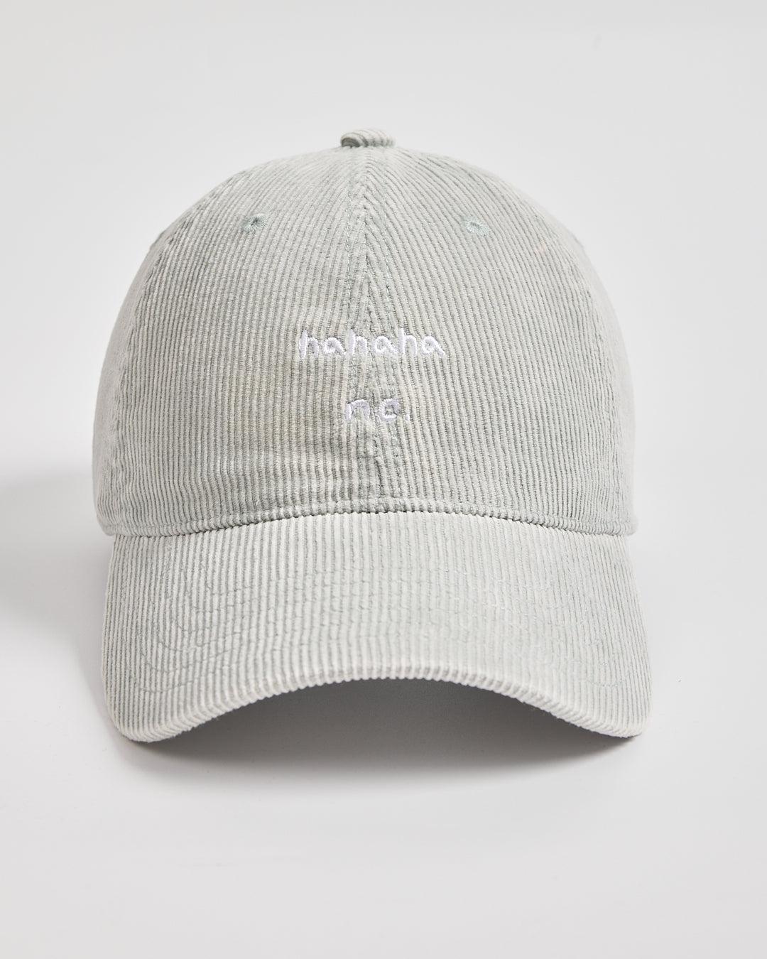 Gray corduroy cap with white text on a light gray background