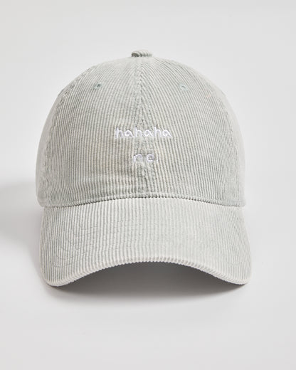 Gray corduroy cap with white text on a light gray background
