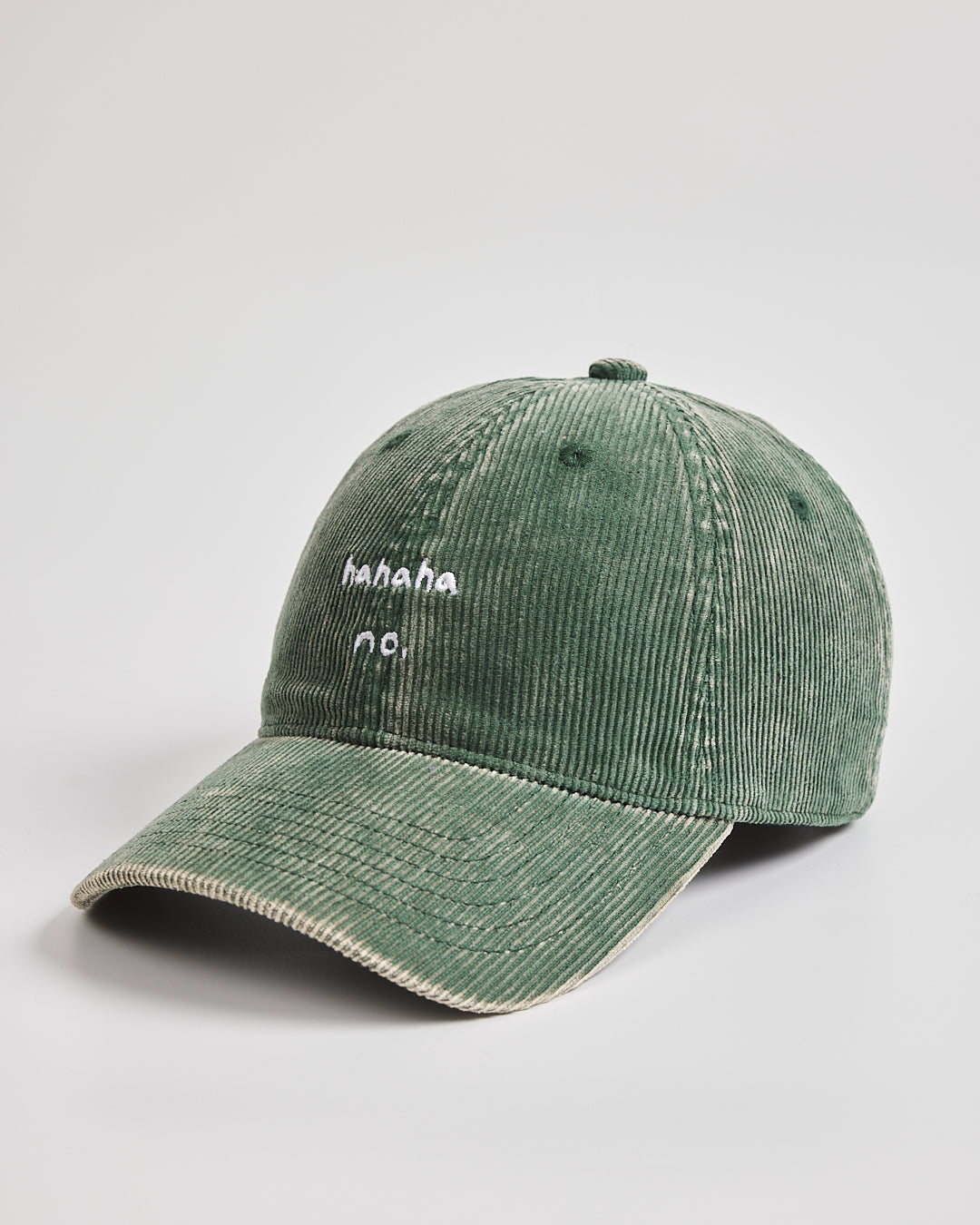 Green corduroy cap with text on a light gray background