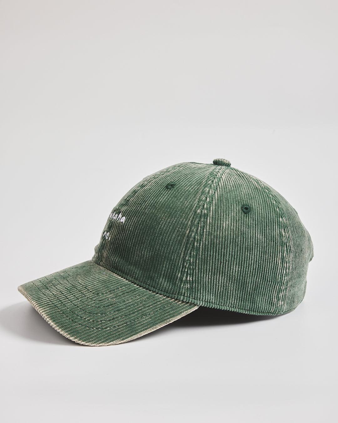 Green corduroy cap on a light gray background