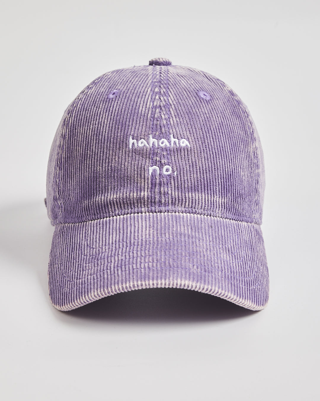 Purple corduroy cap with 'hahaha no.' text on a light gray background