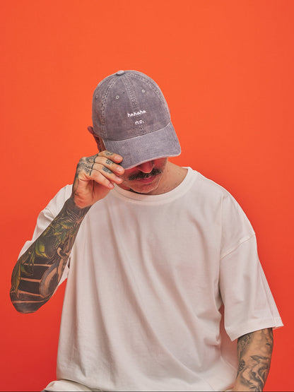 Person wearing a gray cap and white t-shirt against an orange background