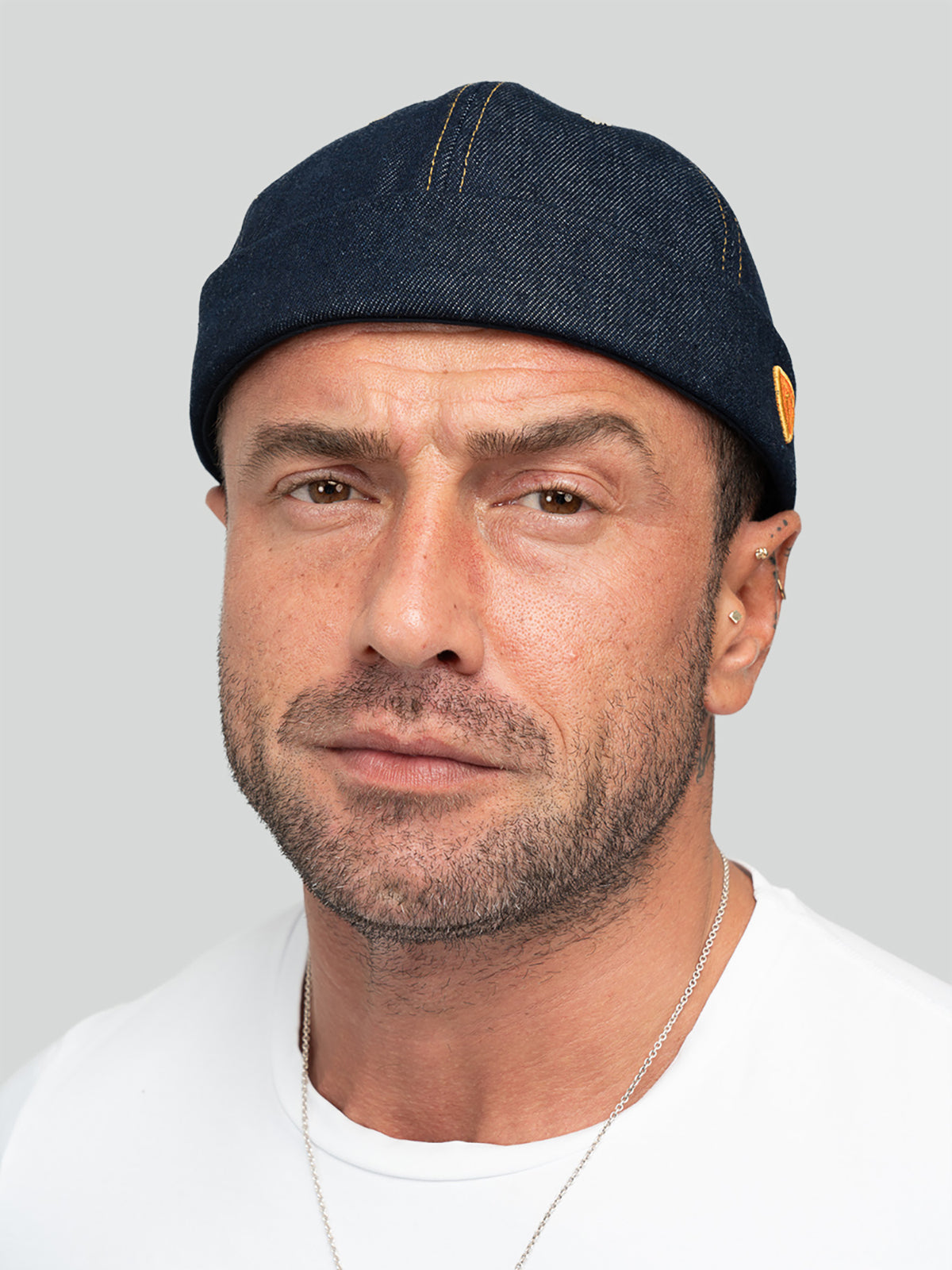 Man wearing Hands Off Denim Docker Hat against a light gray background