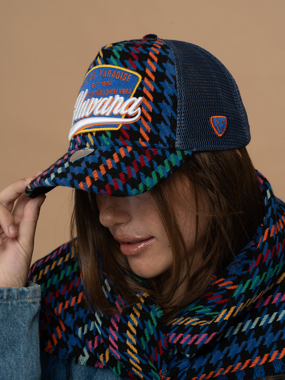 Person wearing Havana Indigo Trucker Hat against a brown background