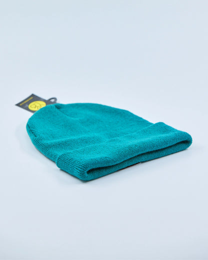 Teal beanie with a tag on a light gray background