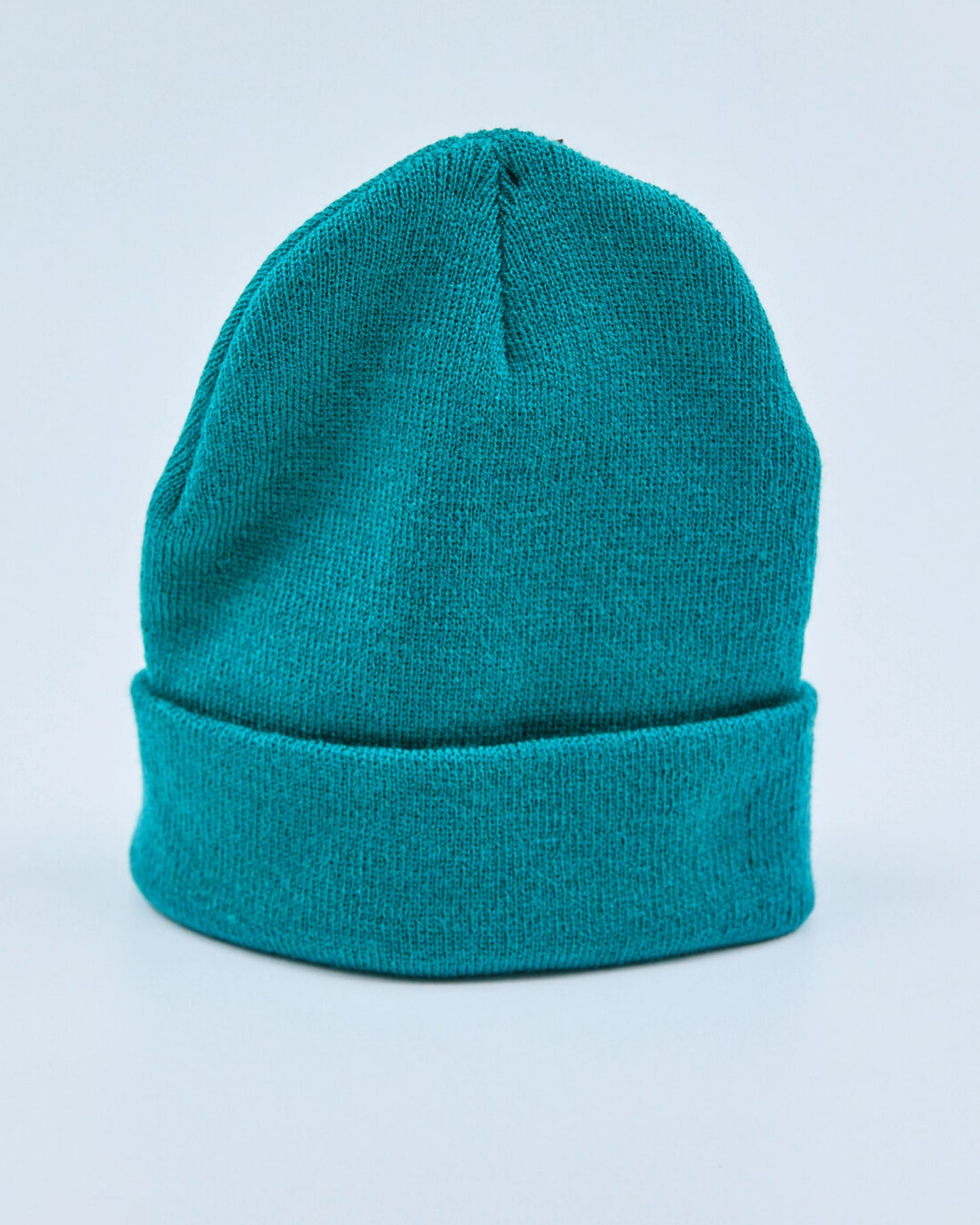 Teal beanie on a light blue background