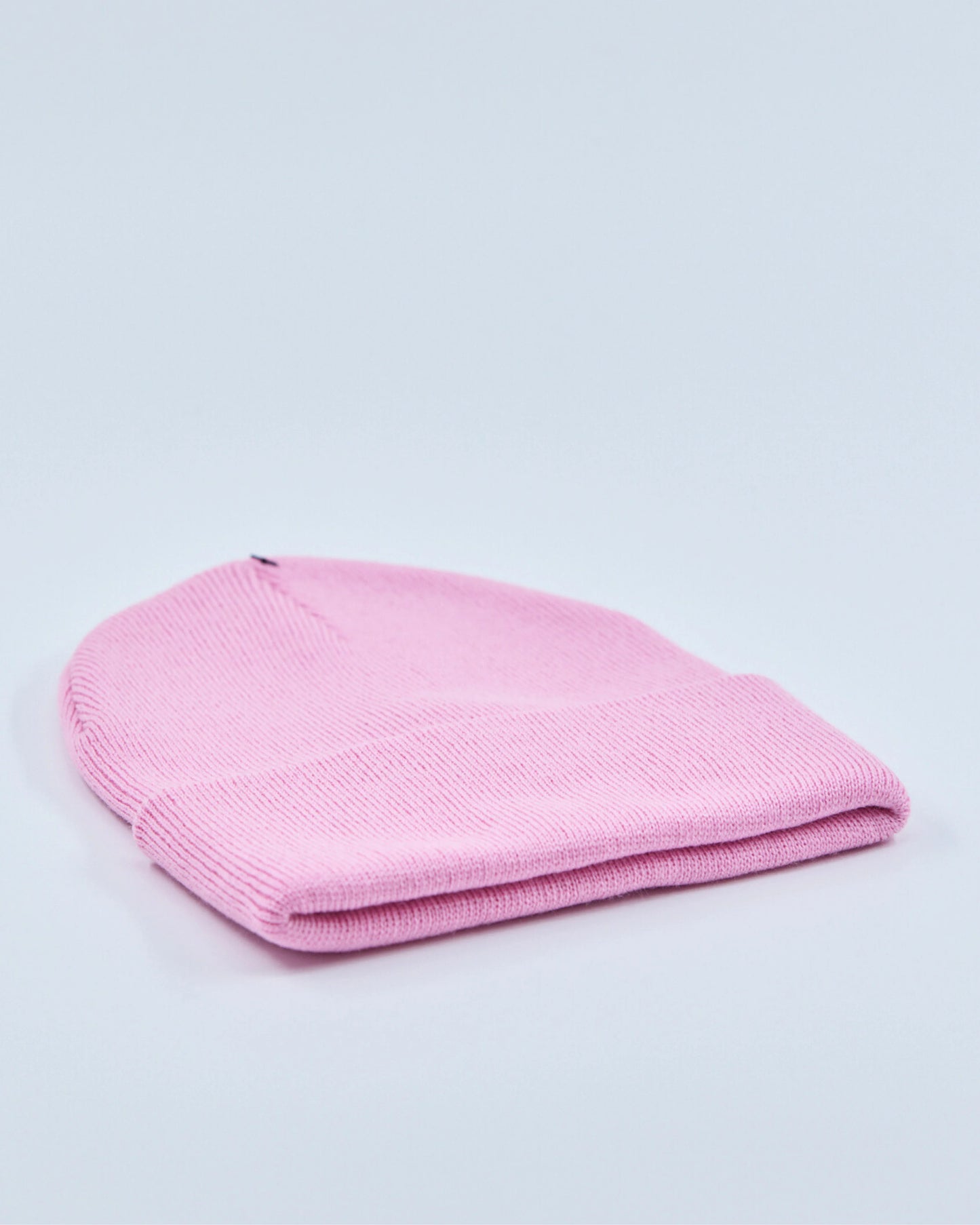 Light pink beanie hat on a light gray background