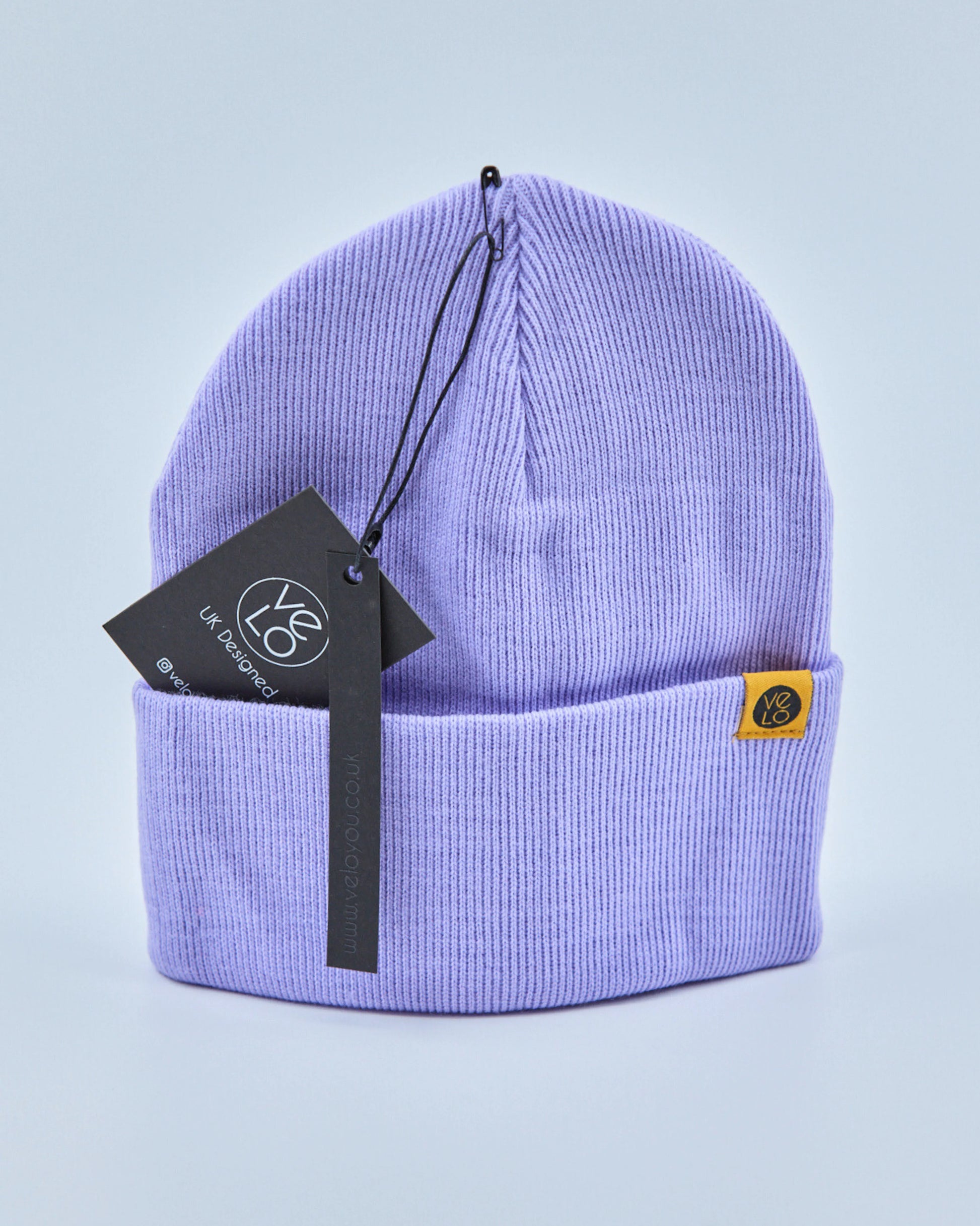 Lilac purple beanie with a brand tag on a light purple background